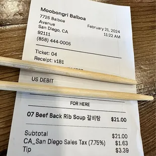 a receipt and a pair of chopsticks