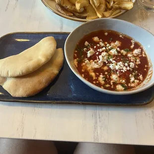 Shakshuka 2 perfectly poached eggs with spiced tomatoes topped with feta.