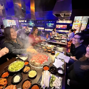 a group of people sitting around a table of food