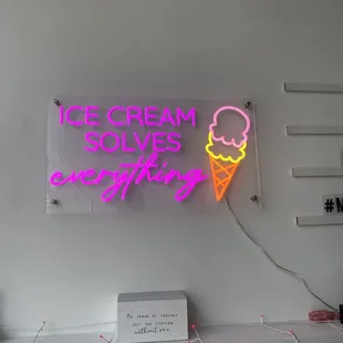 a neon sign that says ice cream solves everything