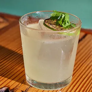 a glass of water with a lime garnish