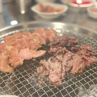 meat and vegetables cooking on a grill