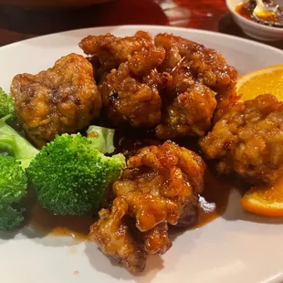 a plate of food with broccoli and orange slices