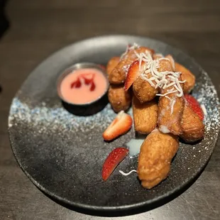 Korean fried donuts with strawberry glaze and vanilla shavings. Raspberry &amp; Strawberry dipping sauce.