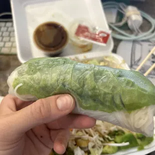 a hand holding a roll of lettuce
