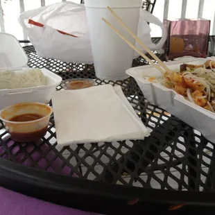 a tray of noodles and chopsticks on a table
