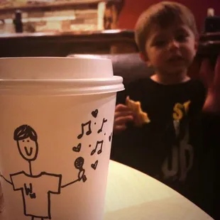 a cup of coffee with a drawing on it