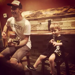 a man playing guitar with a young boy