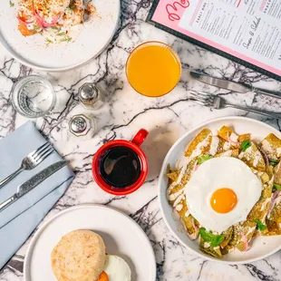 a breakfast of eggs, hash browns, and biscuits