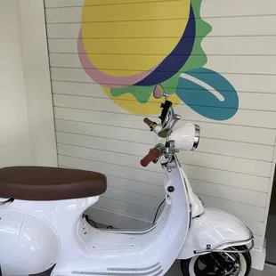 a scooter parked in front of a mural