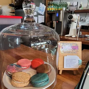 a display of macarons under a glass dome