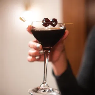 a woman holding a cocktail glass