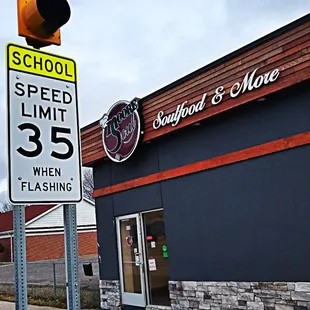 a speed limit sign in front of a store