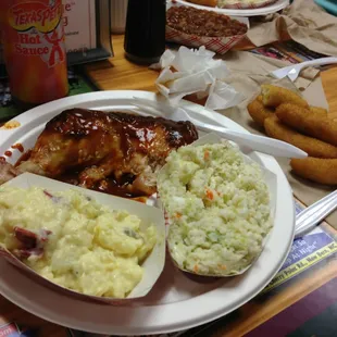 BBQ chicken with cole slaw, potato salad, and hush puppies