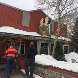 two men standing outside of a restaurant