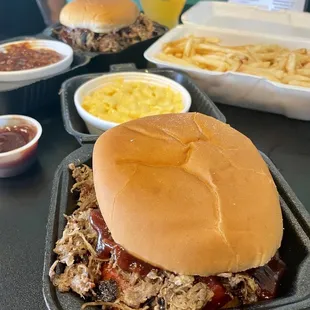 a pulled pork sandwich with a side of macaroni and cheese
