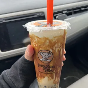 a hand holding a cup of iced coffee