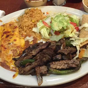 Tampiqueña Plate - 1 cheese enchilada, 1 taco, rice, beans, grilled fajitas, salad and guacamole with tortillas.  Delicious.