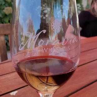 a glass of wine on a wooden table