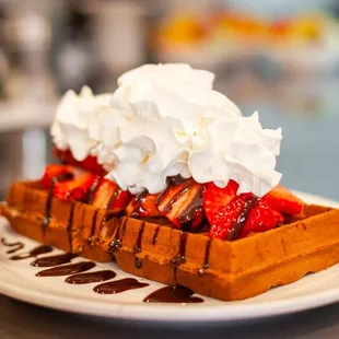 a waffle with whipped cream and strawberries