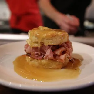 a ham and cheese biscuit sandwich on a white plate