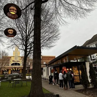 a group of people standing outside a cafe