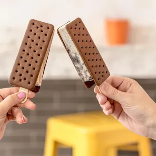two hands holding ice cream sandwiches