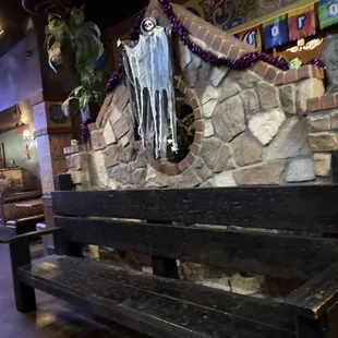 a wooden bench in front of a stone wall