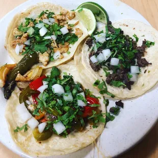 Pollo, asada, and rajas y queso (bell peppers and cheese) tacos with cilantro and onions