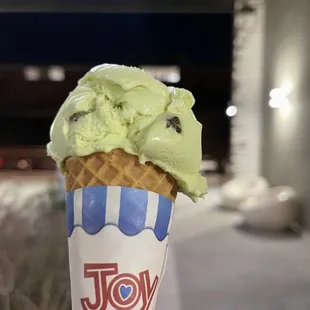 a hand holding a cone of ice cream