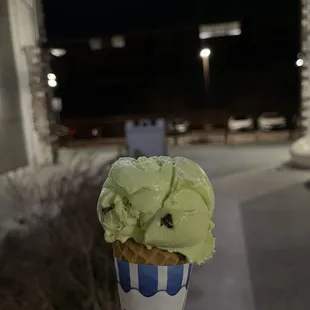 a hand holding a cone of ice cream