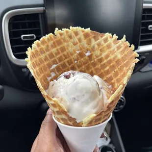 a hand holding a waffle cone