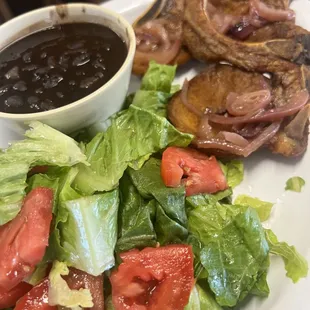 Fried pork chops with salad and black beans