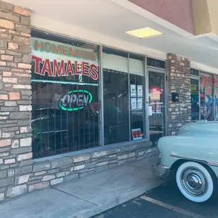a classic car parked in front of a restaurant