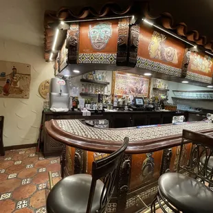 a bar with stools and a tiled floor