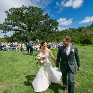 a bride and groom walking down the aisle
