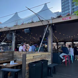 people sitting at tables under a canopy