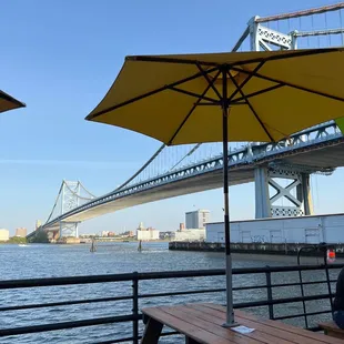 a man sitting at a picnic table under an umbrella