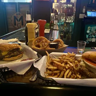 Triple smash burger with American cheese (left), onion rings, double smash burger with pepper jack and fries (right)