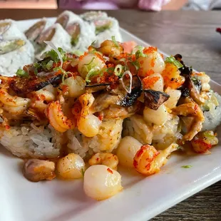 Angry Lobster Roll California Maki topped with scallop, langostino, mushroom, masago, eel sauce. It&apos;s amazing!