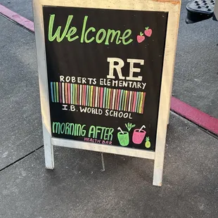 a welcome sign on a sidewalk