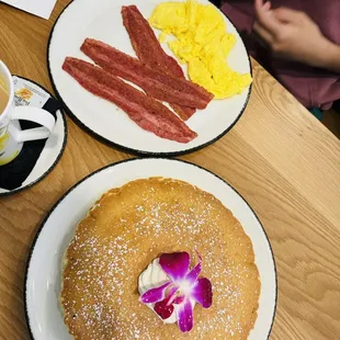 a breakfast of pancakes, bacon and eggs