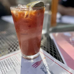 a glass of bloody drink on a table