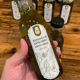 a hand holding a bottle of olive oil