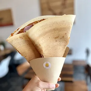 a person holding a cone of food