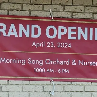 Grand opening sign with hours