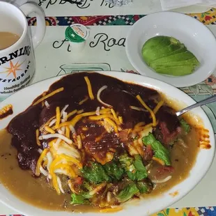 Huevos Rancheros plate with both salsas on top with a side of avocado.