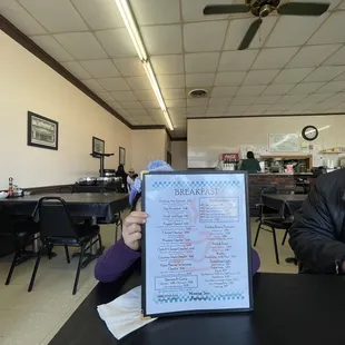 a man sitting at a table with a menu