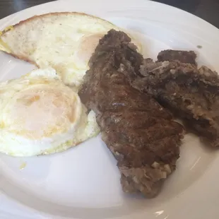 Eggs over easy and meat grits