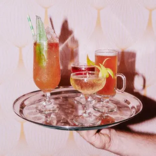 a person holding a tray with drinks